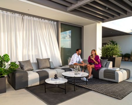 Sofá de exterior con esquina a la izquierda en dos tonos de gris, de tela Sunbrella «Lazy Beach»